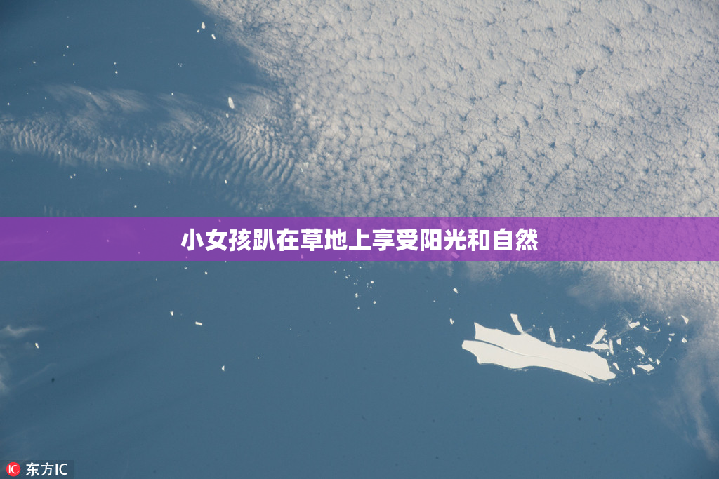 小女孩趴在草地上享受阳光和自然